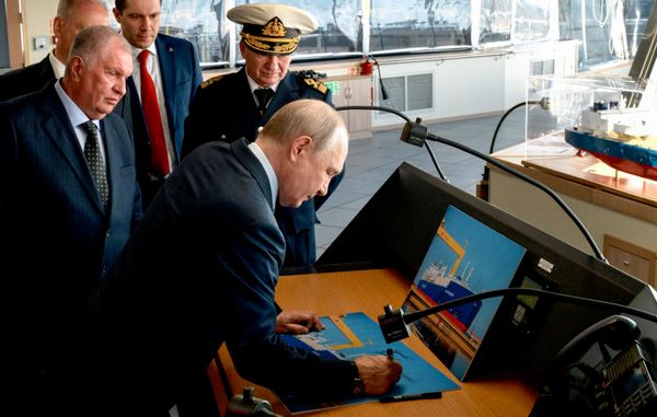 Владимир Путин оставляет автограф во время осмотра танкера-газовоза "Петр Столыпин" для проекта "Арктик СПГ-2" на верфи "Звезда". Слева — главный исполнительный директор, председатель правления, заместитель председателя совета директоров ПАО "НК "Роснефть" Игорь Сечин - Sputnik Азербайджан