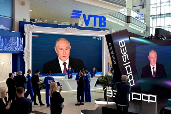 Посетители форума смотрят трансляцию пленарного заседания с участием Путина. - Sputnik Азербайджан