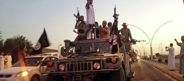 In this file photo taken Monday, June 23, 2014, fighters from the Islamic State group parade in a commandeered Iraqi security forces armored vehicle down a main road at the northern city of Mosul, Iraq. In this file photo taken Monday, June 23, 2014, fighters from the Islamic State group parade in a commandeered Iraqi security forces armored vehicle down a main road at the northern city of Mosul, Iraq. - Sputnik Азербайджан