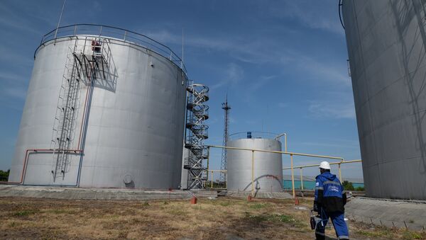 An employee of Gazprom-Neft's Novosibirsk petroleum base near fuel storage tanks - Sputnik Azərbaycan