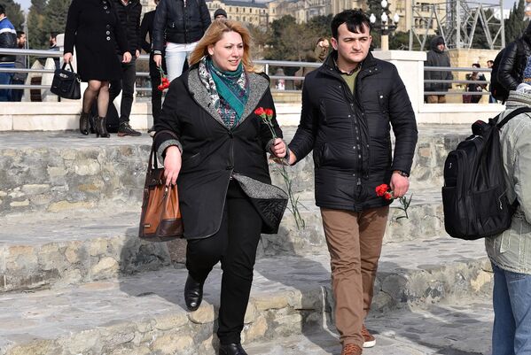 Мужчина и женщина с гвоздиками направляются к берегу - Sputnik Азербайджан
