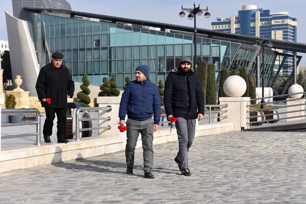 Мужчины с гвоздиками в руках на бакинском бульваре - Sputnik Азербайджан