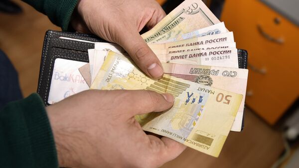 Мужчина пересчитывает полученные деньги, фото из архива - Sputnik Азербайджан