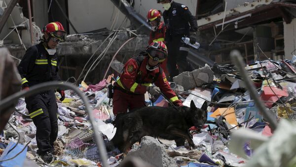 Спасатели извлекают из-под завалов тела погибших на месте разрушений в деревне Манта, Эквадор. Архивное фото - Sputnik Азербайджан