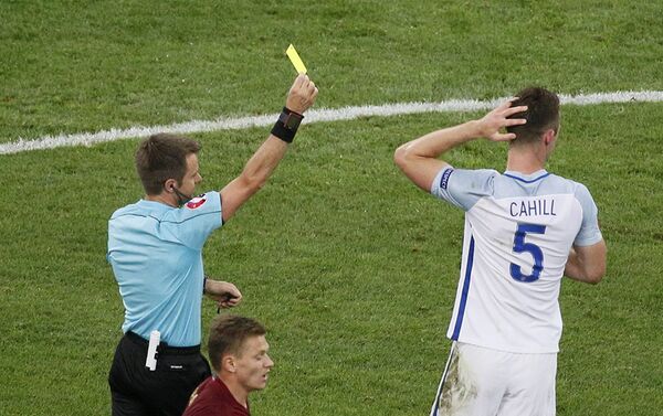 Судья матча Никола Риццоли показывает желтую карточку Гари Кэхиллу (Англия) - Sputnik Азербайджан