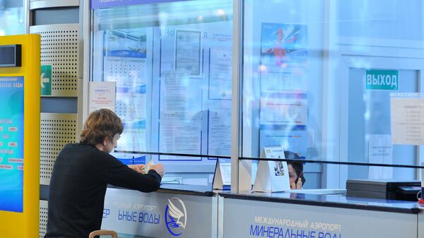 Молодой человек покупает билет в кассе международного аэропорта Молодой человек покупает билет в кассе международного аэропорта - Sputnik Азербайджан