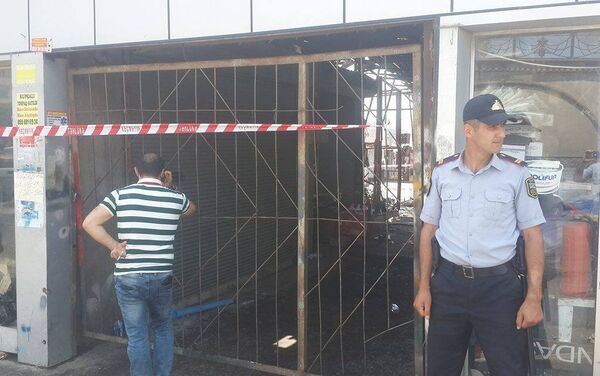 У входа в рынок дежурят сотрудники Управления полиции Хатаинского района и никого внутрь не пускают - Sputnik Азербайджан