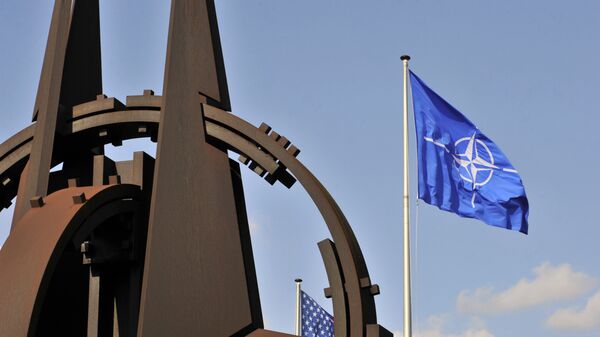 Эмблема и флаг НАТО перед зданием Альянса в Брюсселе - Sputnik Azərbaycan