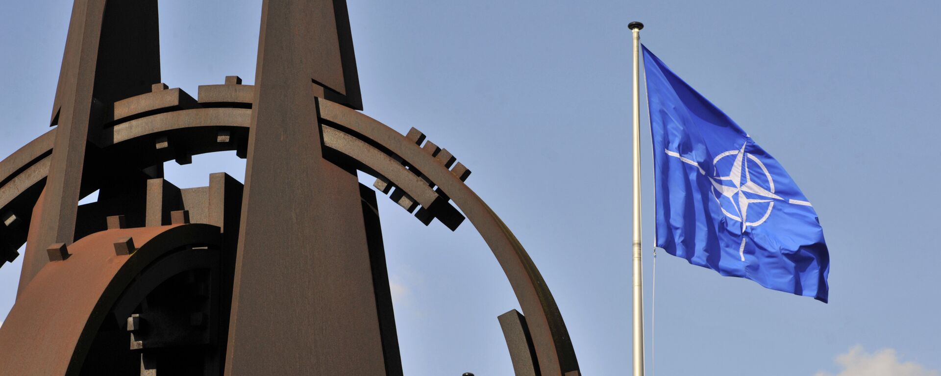 Эмблема и флаг НАТО перед зданием Альянса в Брюсселе - Sputnik Azərbaycan, 1920, 29.11.2019