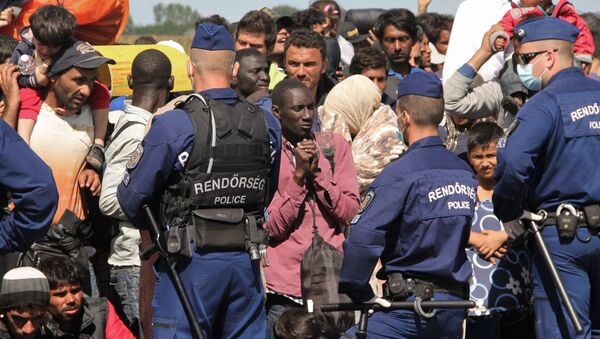 Венгерские полицейские охраняют беженцев, задержанных на границе - Sputnik Азербайджан