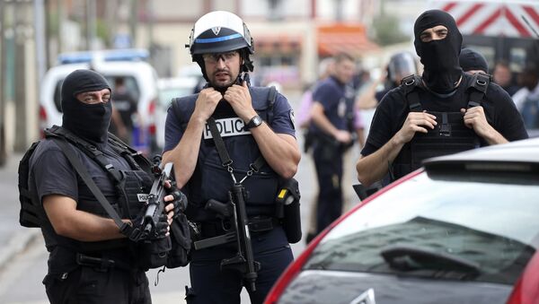 Французский полицейский и члены Бригады по борьбе с преступностью патрулируют улицу в Аржантее, пригороде Парижа. 21 июля 2016 года - Sputnik Азербайджан
