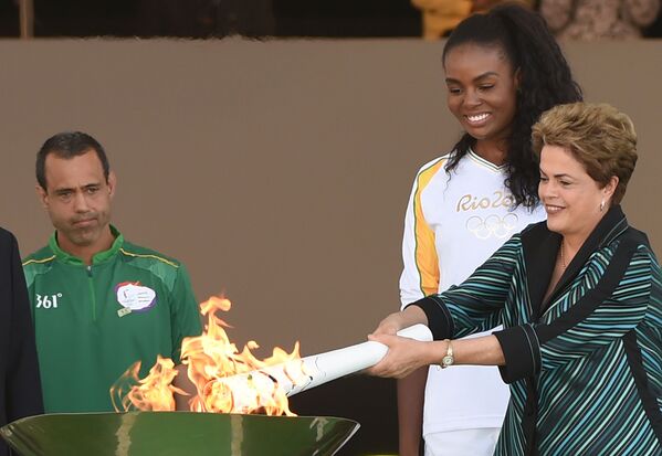 Эстафета олимпийского огня в Бразилии стартовала из Дворца Планалту в Бразилиа - из рабочей резиденции президента страны Дилмы Руссефф, которая вручила зажженный факел двукратной олимпийской чемпионке - волейболистке Фабиане Клаудино - Sputnik Азербайджан