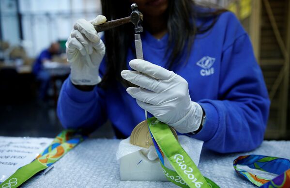 Работник из Casa da Moeda do Brasil (бразильский монетный двор) готовит олимпийскую медаль Рио 2016. - Sputnik Азербайджан