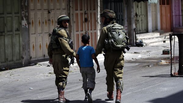 Израильские солдаты арестовывают палестинского мальчика после столкновений в центре города на Западном берегу Хеврон. 20 июня 2014 года - Sputnik Азербайджан