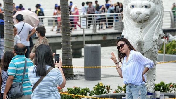 Девушка со смартфоном в сингапурском парке Мерлайон - Sputnik Азербайджан