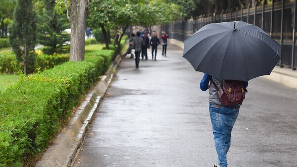 Прохожий с зонтиком на улице в Баку, фото из архива - Sputnik Азербайджан
