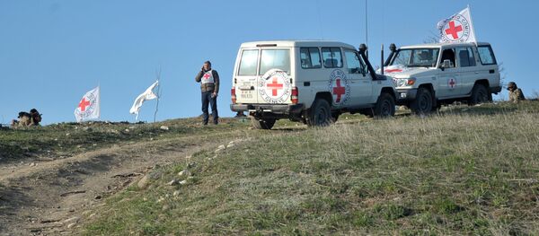 Автомобили представителей Международного комитета Красного Креста во время на линии разграничения, где ведется поиск тел погибших в столкновениях Автомобили представителей Международного комитета Красного Креста во время на линии разграничения, где ведется поиск тел погибших в столкновениях - Sputnik Азербайджан