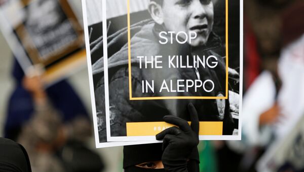 Женщина держит плакат во время акции протеста, призывая к прекращению насилия в Алеппо - Sputnik Азербайджан