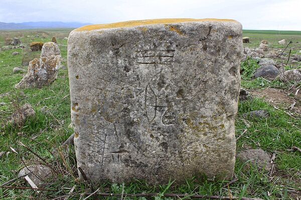 Nərgiztəpədə tapılmış, üzərinə ox, kaman işarələri, damğalardan ibarət naxışlar çəkilmiş qəbirüstü daş Nərgiztəpədə tapılmış, üzərinə ox, kaman işarələri, damğalardan ibarət naxışlar çəkilmiş qəbirüstü daş - Sputnik Azərbaycan