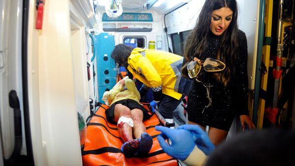 Врач оказывает помощь раненой на месте теракта девушке, Стамбул, 1 января 2017 года - Sputnik Азербайджан