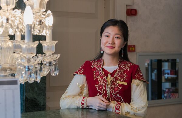 Приветливая девушка в национальном костюме за стойкой ресепшен отеля Rixos President Astana. - Sputnik Азербайджан