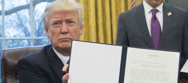 Президент США Дональд Трамп держит в руках распоряжение о выводе США из Транс-Тихоокеанского партнерства после его подписания в Овальном кабинете Белого дома - Sputnik Азербайджан