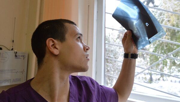 Врач-травматолог смотрит на рентгеновский снимок, фото из архива - Sputnik Азербайджан