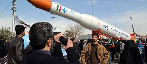 Люди фотографируются у ракеты-носителя Simorgh (Феникс) в день празднования 37-й годовщины Исламской революции, Тегеран, 11 февраля 2016 года - Sputnik Азербайджан