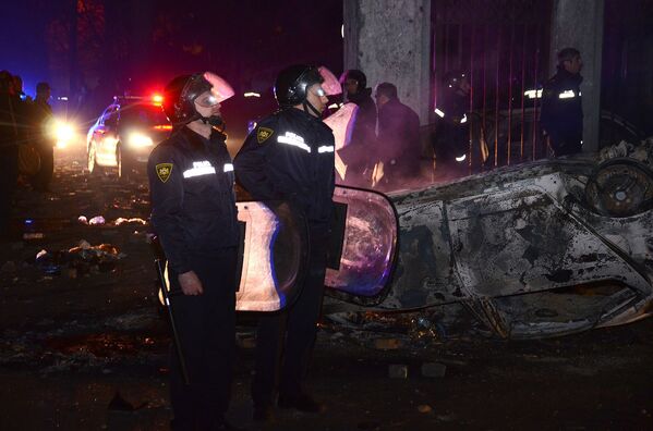 Сотрудники полиции у одной из сгоревших машин после завершения операции по наведению порядка в Батуми - Sputnik Азербайджан