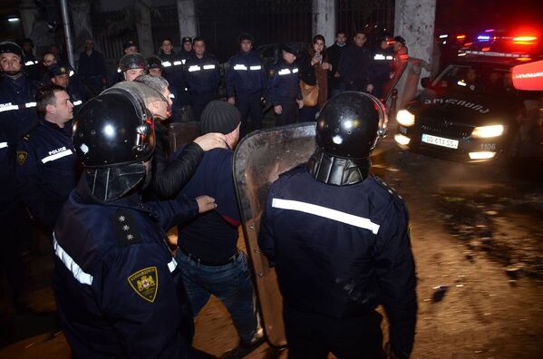 Сотрудники полиции ведут одного из задержанных участников беспорядков в Батуми - Sputnik Азербайджан