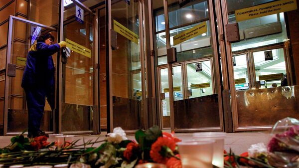 Цветы и свечи у входа в вестибюль станции метро Спасская в память о погибших в результате взрыва в метрополитене Санкт-Петербург - Sputnik Азербайджан