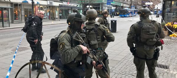 Полицейские в центре Стокгольма после наезда грузовика на людей на улице Дроттнинггатан. 7 апреля 2017 года - Sputnik Азербайджан