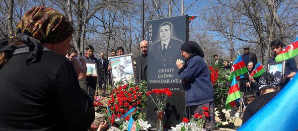 Близкие возле могилы шехида Бабека Абидова Близкие возле могилы шехида Бабека Абидова - Sputnik Азербайджан