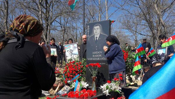 Близкие возле могилы шехида Бабека Абидова - Sputnik Азербайджан