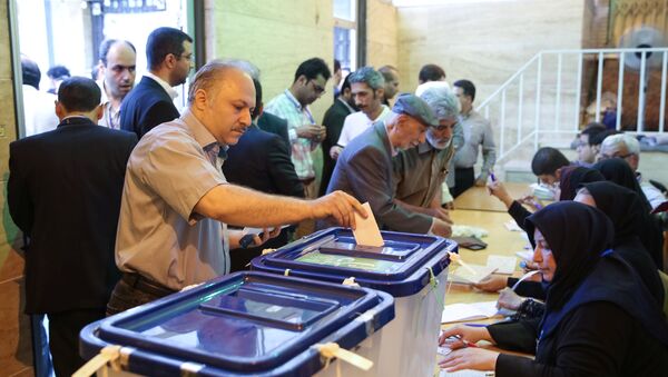 Люди голосуют в ходе президентских выборов на одном из избирательных участков в Тегеране, 19 мая 2017 года - Sputnik Azərbaycan