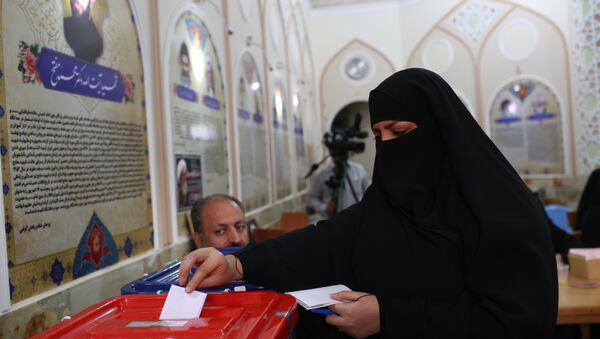 Иранская женщина голосует на президентских выборах в городе Кум, 130 км южнее Тегерана, 19 мая 2017 года - Sputnik Азербайджан