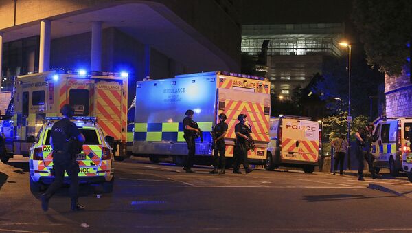 Armed police positioned near emergency vehicles after reports of an explosion at the Manchester Arena during an Ariana Grande concert in Manchester, England Monday, May 22, 2017. - Sputnik Азербайджан