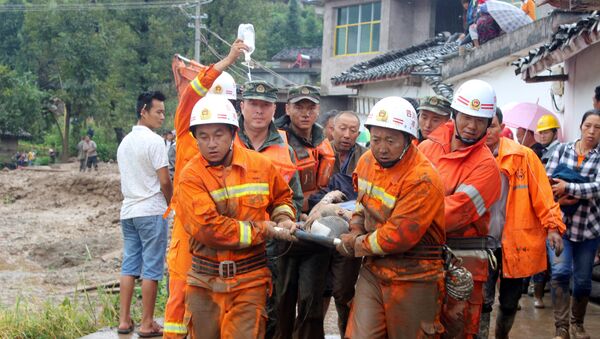 Спасатели треанспортируют пострадавшего при сходе селя в провинции Сычуань в Китае. 8 августа 2017 года - Sputnik Азербайджан