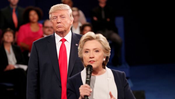 Республиканский кандидат в президенты США Дональд Трамп слушает, как кандидат от Демократической партии Хиллари Клинтон отвечает на вопрос от аудитории во время дебатов в президентской мэрии в Вашингтонском университете в Сент-Луисе, штат Миссури, США, 9 октября 2016 года - Sputnik Азербайджан