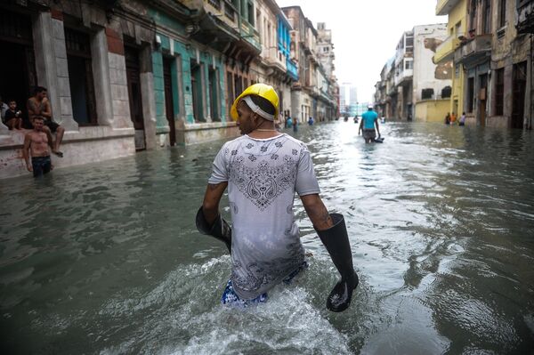 Кубинцы идут по затопленной улице в Гаване после урагана Ирма, обрушившегося на остров - Sputnik Azərbaycan