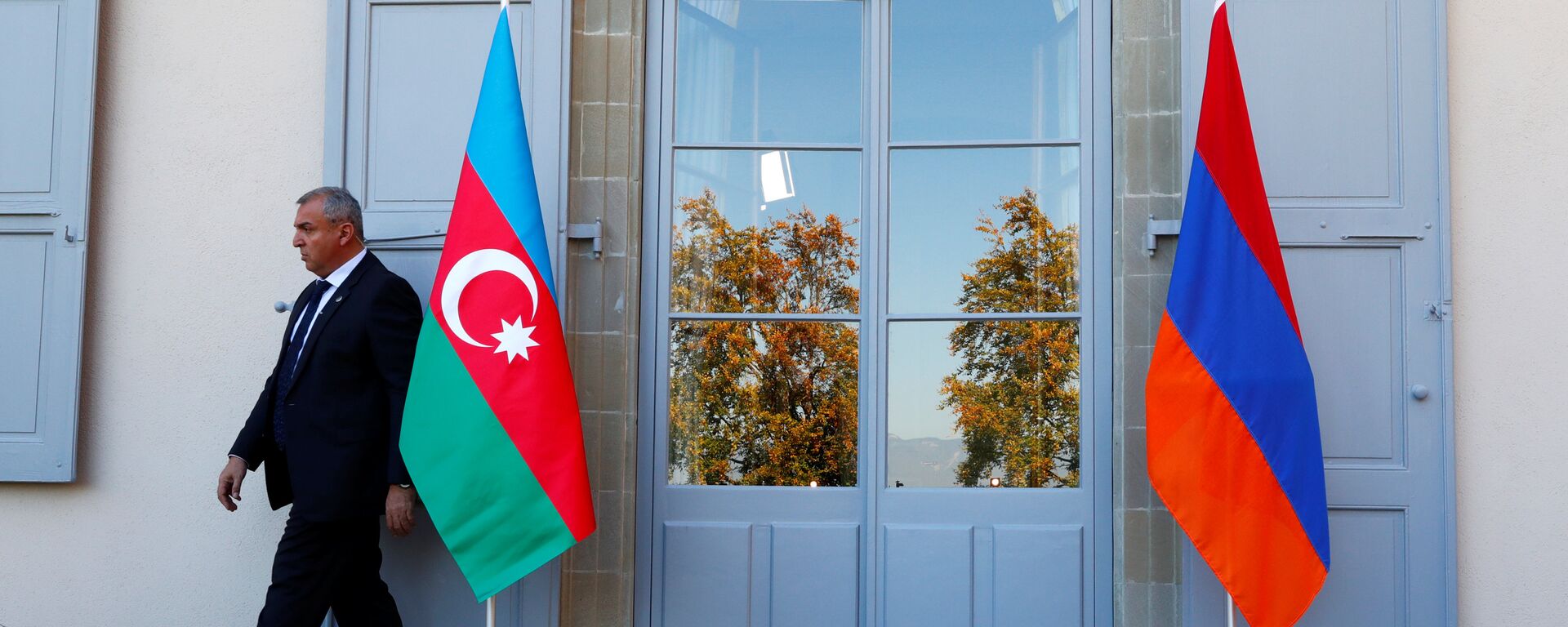 Охранник проходит мимо азербайджанского (слева) и армянского флага на открытии переговоров в Женеве, Швейцария - Sputnik Azərbaycan, 1920, 15.04.2021