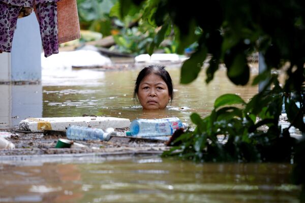 Женщина пробирается через затопленную улицу после тайфуна Дамри, Вьетнам - Sputnik Азербайджан