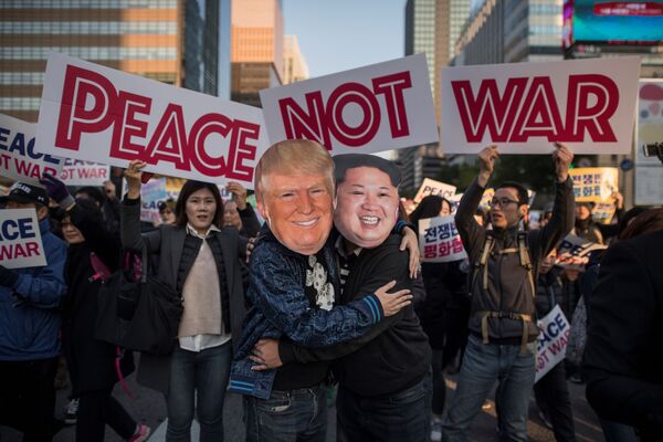 Демонстранты в масках, изображающих Дональда Трампа и Ким Чен Ына, во время митинга в Сеуле. - Sputnik Азербайджан