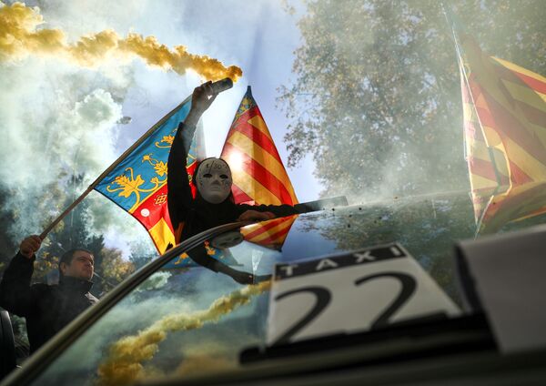 Человек в маске и дымовой шашкой во время забастовки таксистов в Мадриде - Sputnik Азербайджан