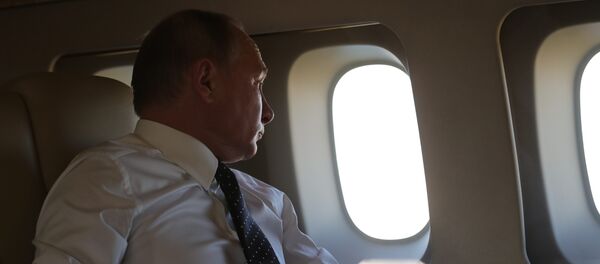 Президент РФ Владимир Путин на борту президентского самолета во время полета на авиабазу Хмеймим в Сирии - Sputnik Азербайджан