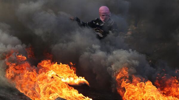 Протестующий во время столкновений на границе Палестины и Израиля в районе Рамаллы - Sputnik Azərbaycan