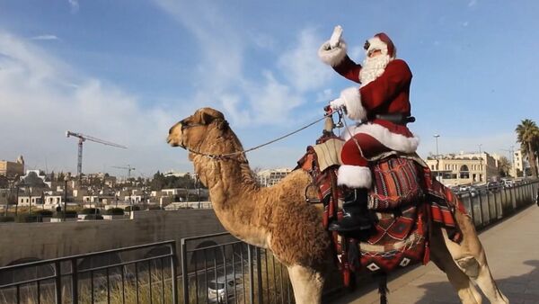 Санта-Клаус верхом на верблюде в Восточном Иерусалиме - Sputnik Азербайджан