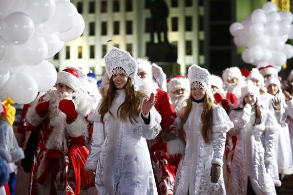 Люди в костюмах Снегурочек и Дед Морозов во время парада в Минске - Sputnik Азербайджан