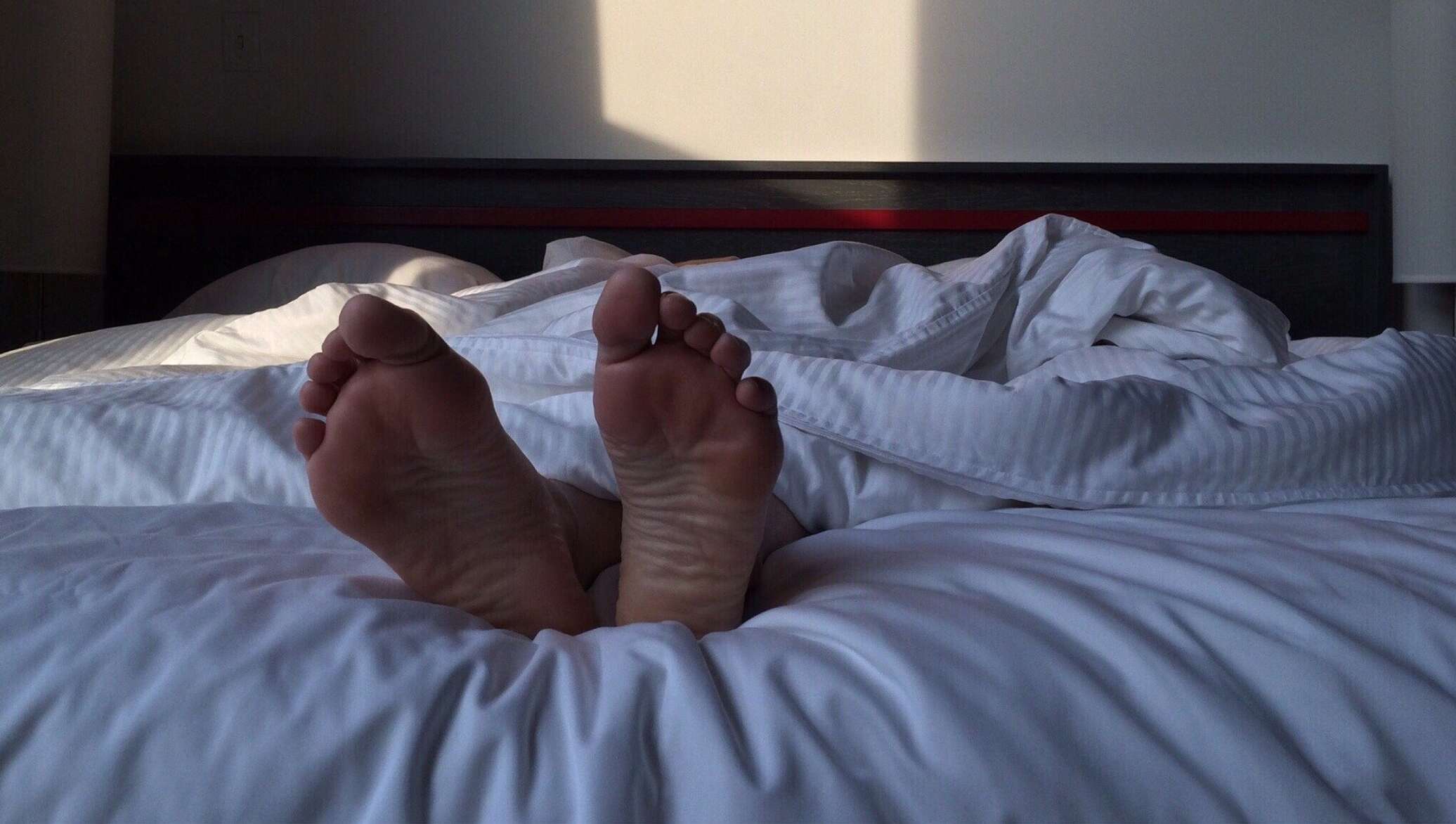 Спать ноги видео. Мужские ноги на кровати. Мужчина в кровати под одеялом. Ножки для кровати.