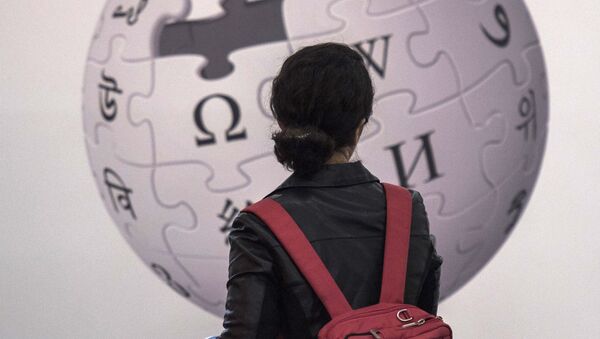 Посетительница стоит перед стендом с изображением логотипа онлайн энциклопедии Wikipedia - Sputnik Азербайджан